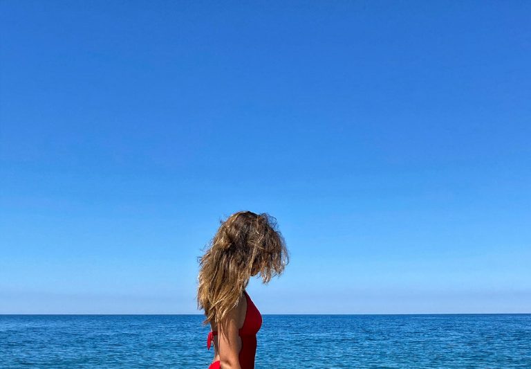 beautiful-girl-on-the-beach-with-long-hair-on-red--42CRBZA